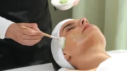 Solari Head Spa applying Eminence Organic Skin Care to a woman relaxing .